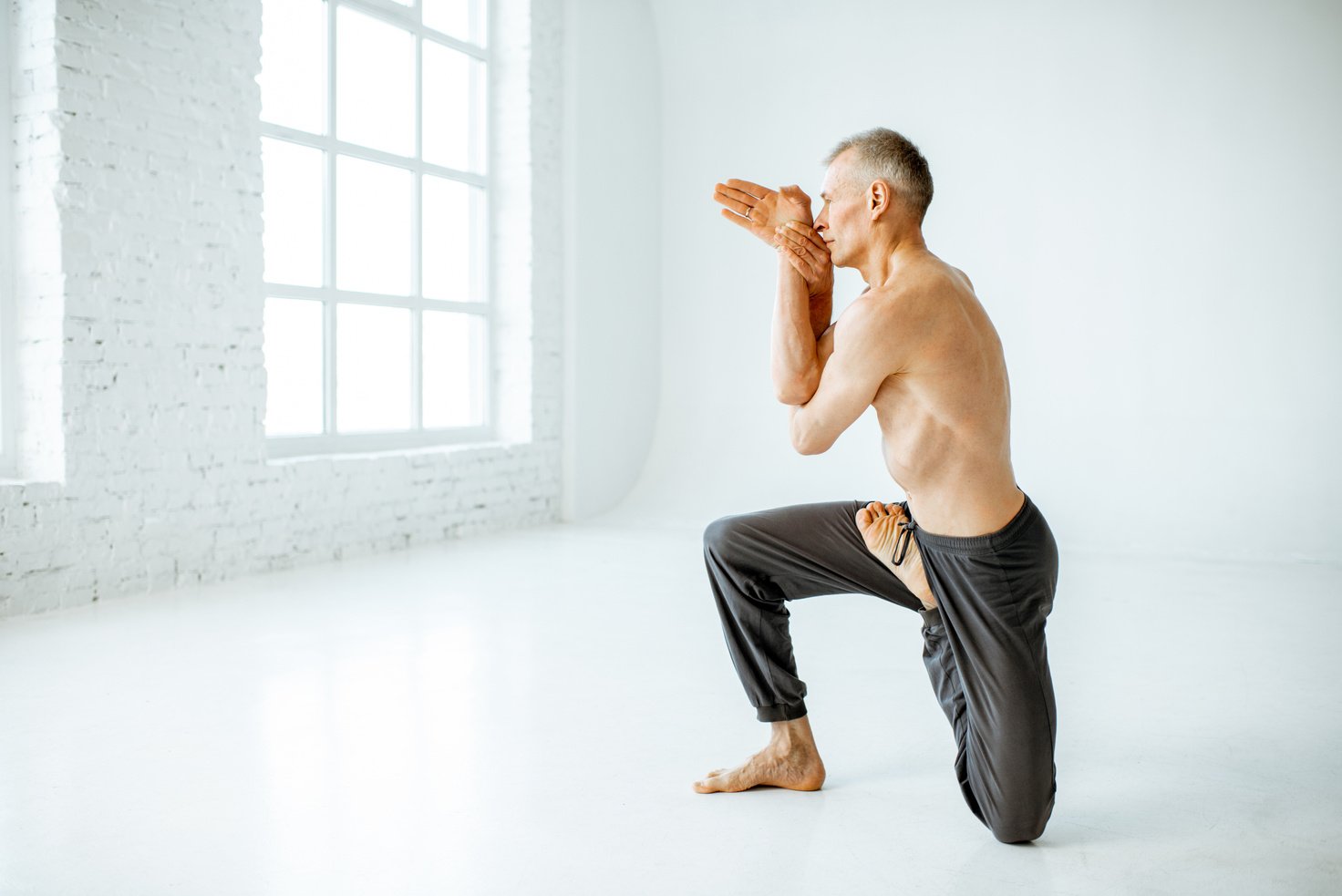 Senior Man Practising Yoga Indoors